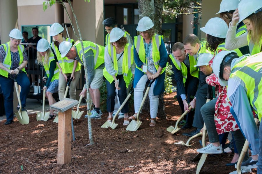 School board members break the ground with golden shovels.