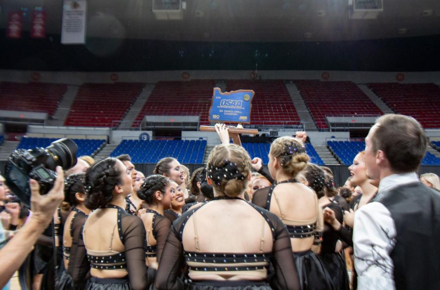The Tigerettes hold up the state trophy on March 15. They won state for the second  year in a row.