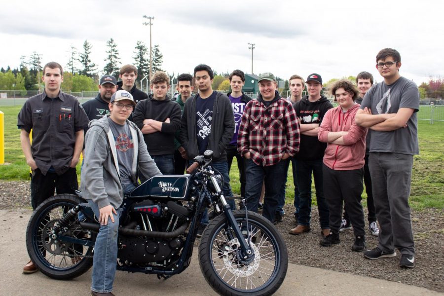 Junior Sterling McKinnon poses with Portland Flyer the bike he helped modify for a world-wide custom motorcycle competition. The Auto Electrical class gathered around to see the results.
