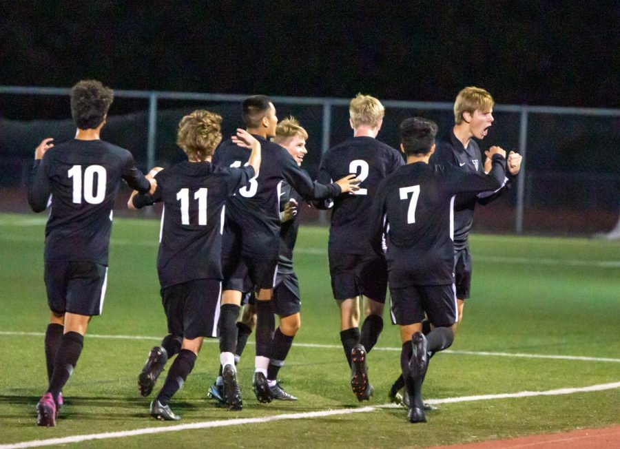 Teammates celebrate with Jared Debban after he scores the games only goal in the boys varsity soccer defeat of Tualatin on Sept. 12.
