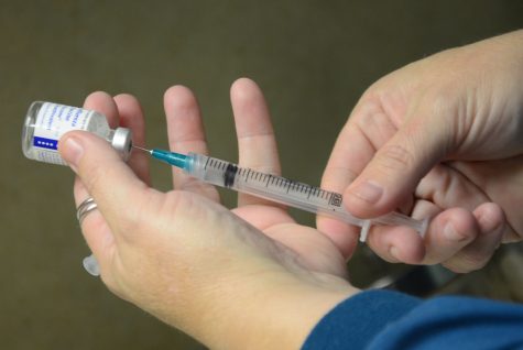 A common sight during vaccination season as a nurse extracts medicine to give to a patient.