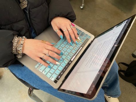 A student pulls out her laptop to take notes in class. Technology has changed the way students learn.
