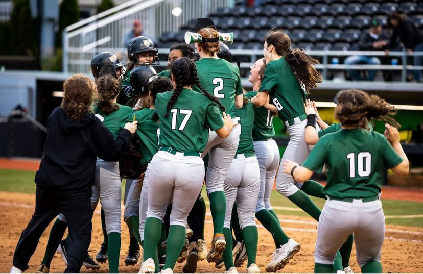 Softball+players+celebrate+immediately+after+winning+the+state+championship.+The+10+inning+game+took+place+on+Tuesday%2C+June+7+at+University+of+Oregon%E2%80%99s+Jane+Sanders+Stadium.